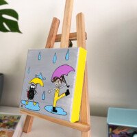 Whimsical painting of a rainy day with a black ladybug in yellow boots holding a yellow umbrella and a smiling girl with pigtails jumping in a puddle with a purple umbrella.